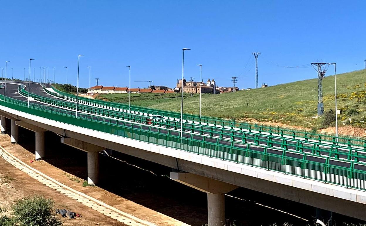 Un vehículo cruza el viaducto con la ciudad monumental al fondo. 