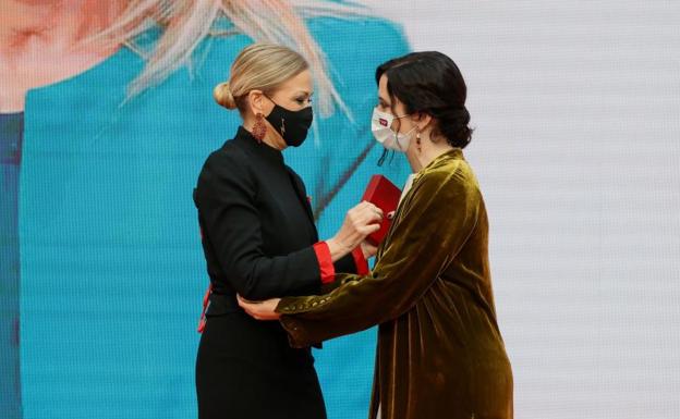 La presidenta de la Comunidad de Madrid, Isabel Díaz Ayuso (d), hace entrega de la Medalla de Oro a la expresidenta regional Cristina Cifuentes.