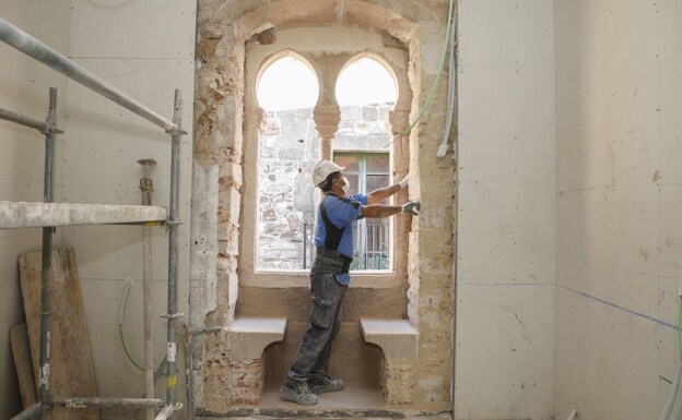 Un operario trabaja en el interior de la Casa Paredes-Saavedra, tras una de las ventanas más características de la histórica construcción. 