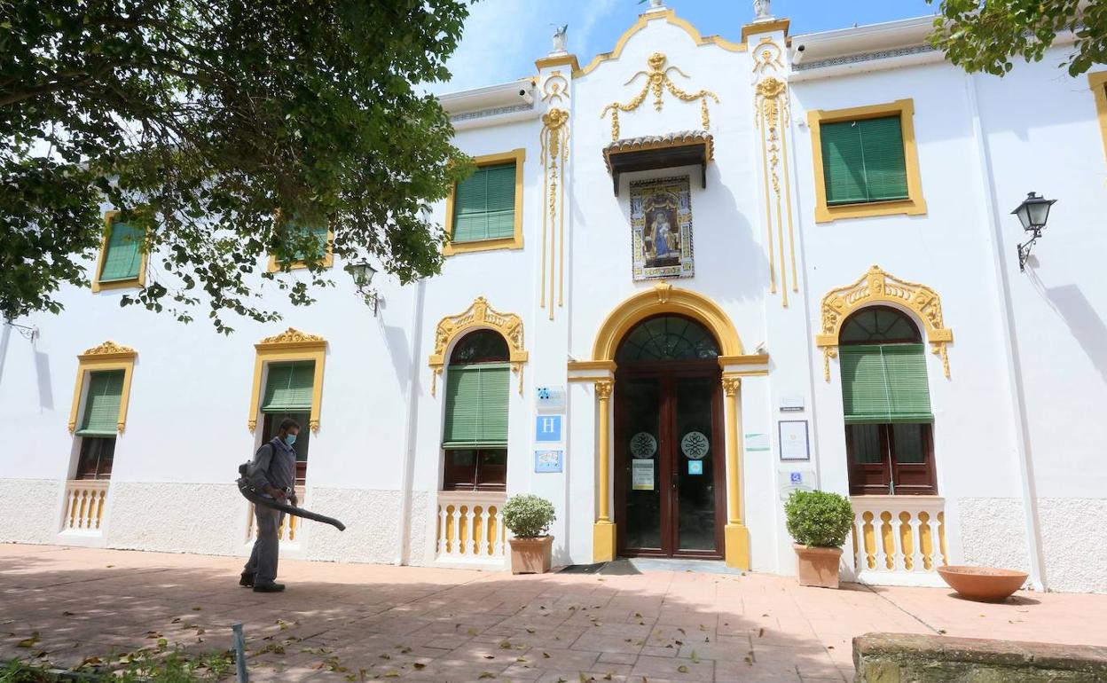 Un trabajador limpia de hojas la entrada del hotel junto al balneario de El Raposo, en el término de Puebla de Sancho Pérez. Los servicios del balneario se reinician hoy. 