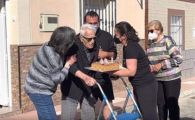 Momento en el que Guadalupe Martín, miembro de la asociación, entrega a Marcelino la tarta de su cumpleaños. 