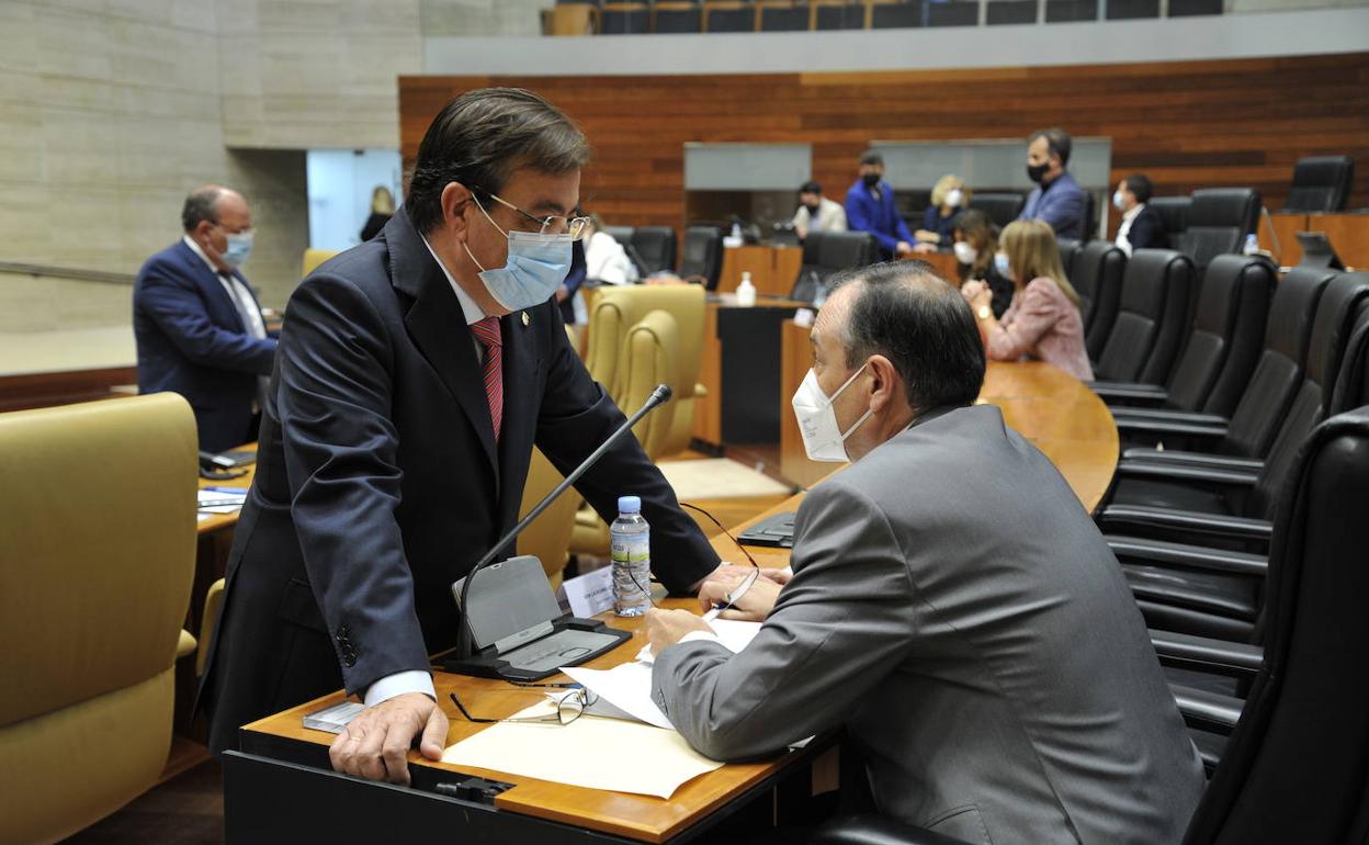 El presidente de la Junta de Extremadura, Guillermo Fernández Vara, charla antes del pleno con el diputado popular Laureano León. 