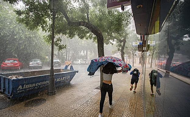 Perfonas se resguradan de la tormenta ayer en Cáceres. Vídeo: Intensa granizada en Don Álvaro. 