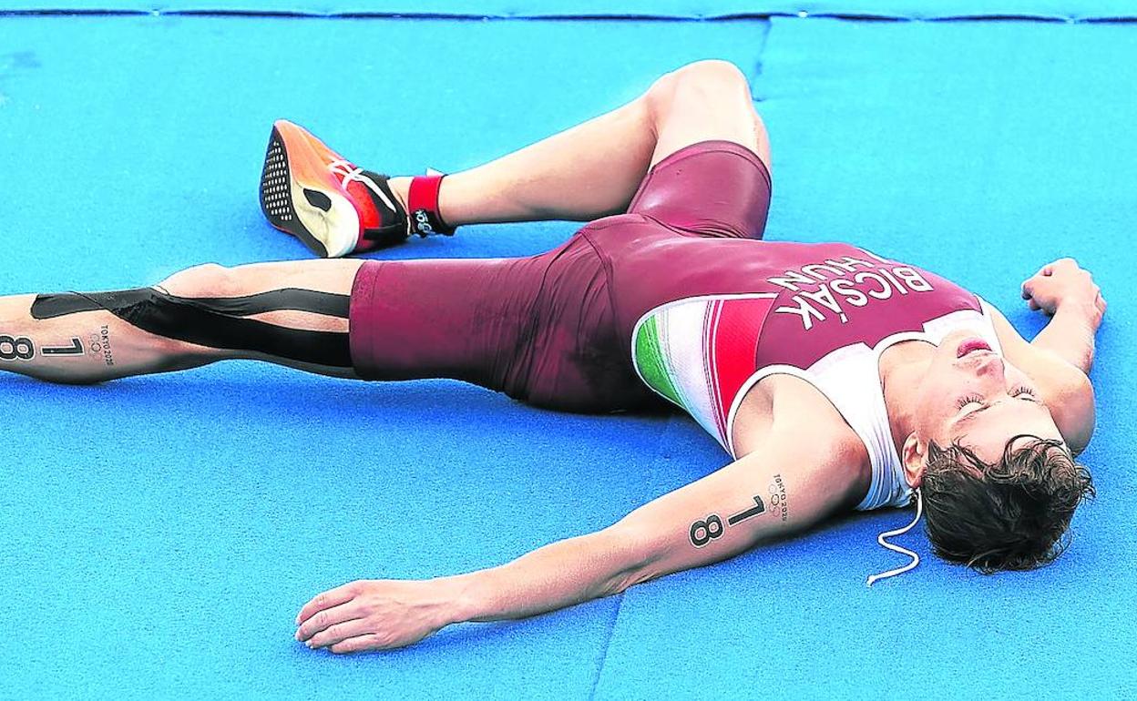 Un triatleta, desfondado junto a la línea de meta, tras soportar temperaturas extremas pese a haberse celebrado la prueba a las seis y media de la mañana