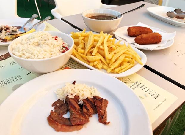 Ponen de guarnición arroz, judías, banana frita y patatas fritas.