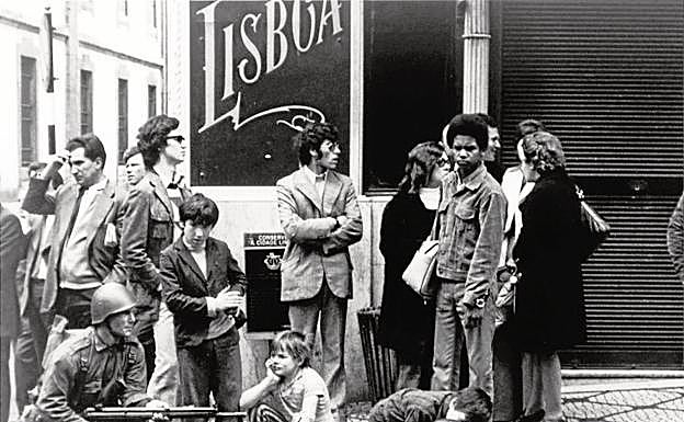 Imagen principal - Arriba, tres niños contemplan a los militares en las calles de Lisboa. Abajo, a la izquierda, una foto del presidente de la Junta de Salvación Nacional, Antonio Spínola; y a la derecha, la portada de HOY del 26 de abril de 1974.