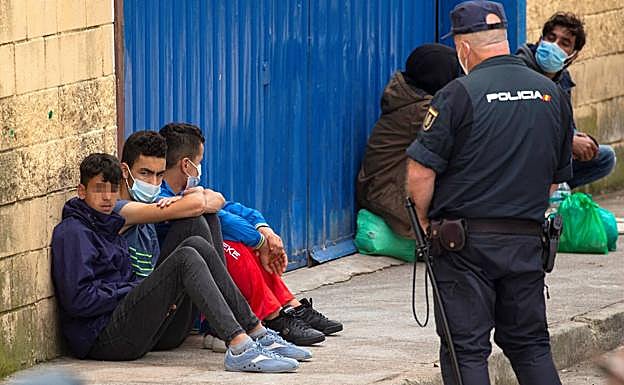 Varios inmigrantes menores en el polígono industrial cercano a la frontera de El Tarajal, en Ceuta.