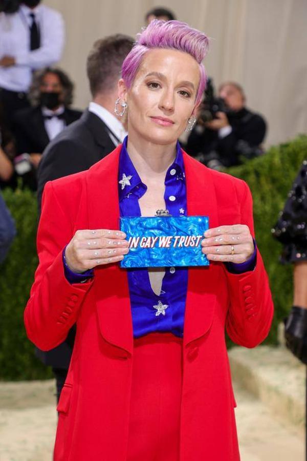 La futbolista Megan Rapinoe, vestida con los colores de la bandera estadounidense y con un bolso con el lema In gay we trust` (En los gays confiamos).