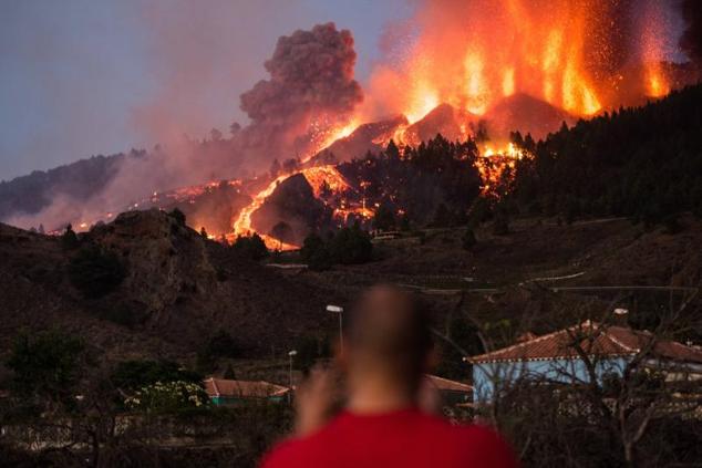 Un vecino observa la lava y el humo tras la erupción del volcán.