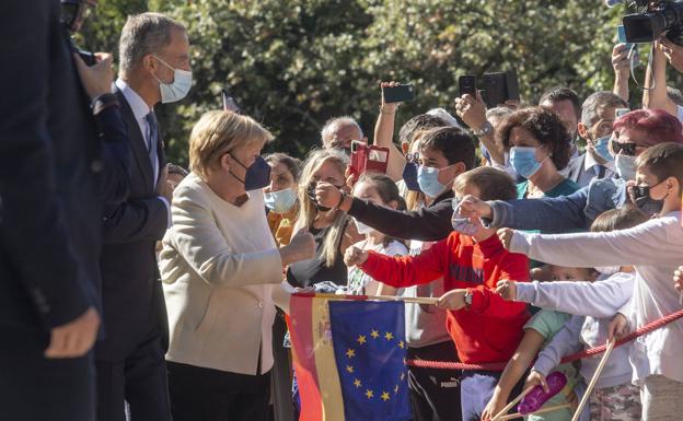 Merkel saluda al público junto al Rey, antes de entrar en el Real Monesterio de Yuste. 