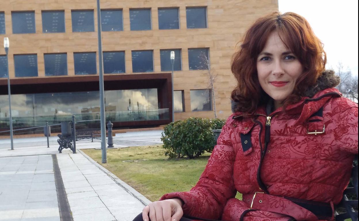 Cintia Díaz-Silveira con el edificio de la Universidad Rey Juan Carlos de Madrid al fondo.