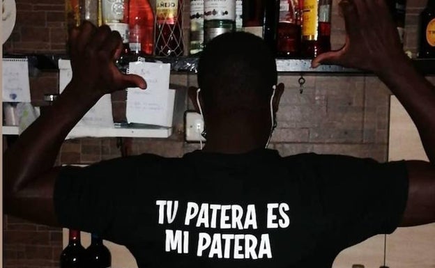 Mass Mbaye, con una camiseta promocional de su bar.