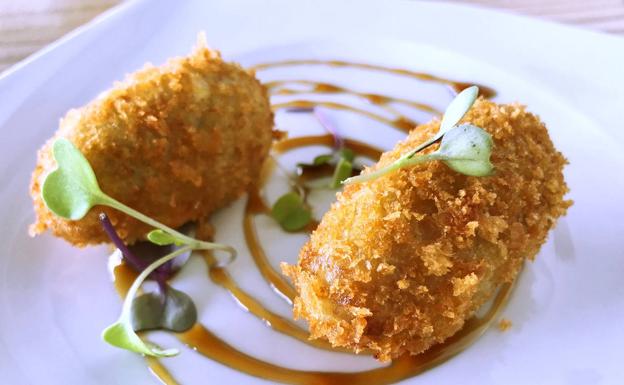 Imagen principal - Aperitivo de croquetas, saquitos de patatera y terraza del establecimiento.