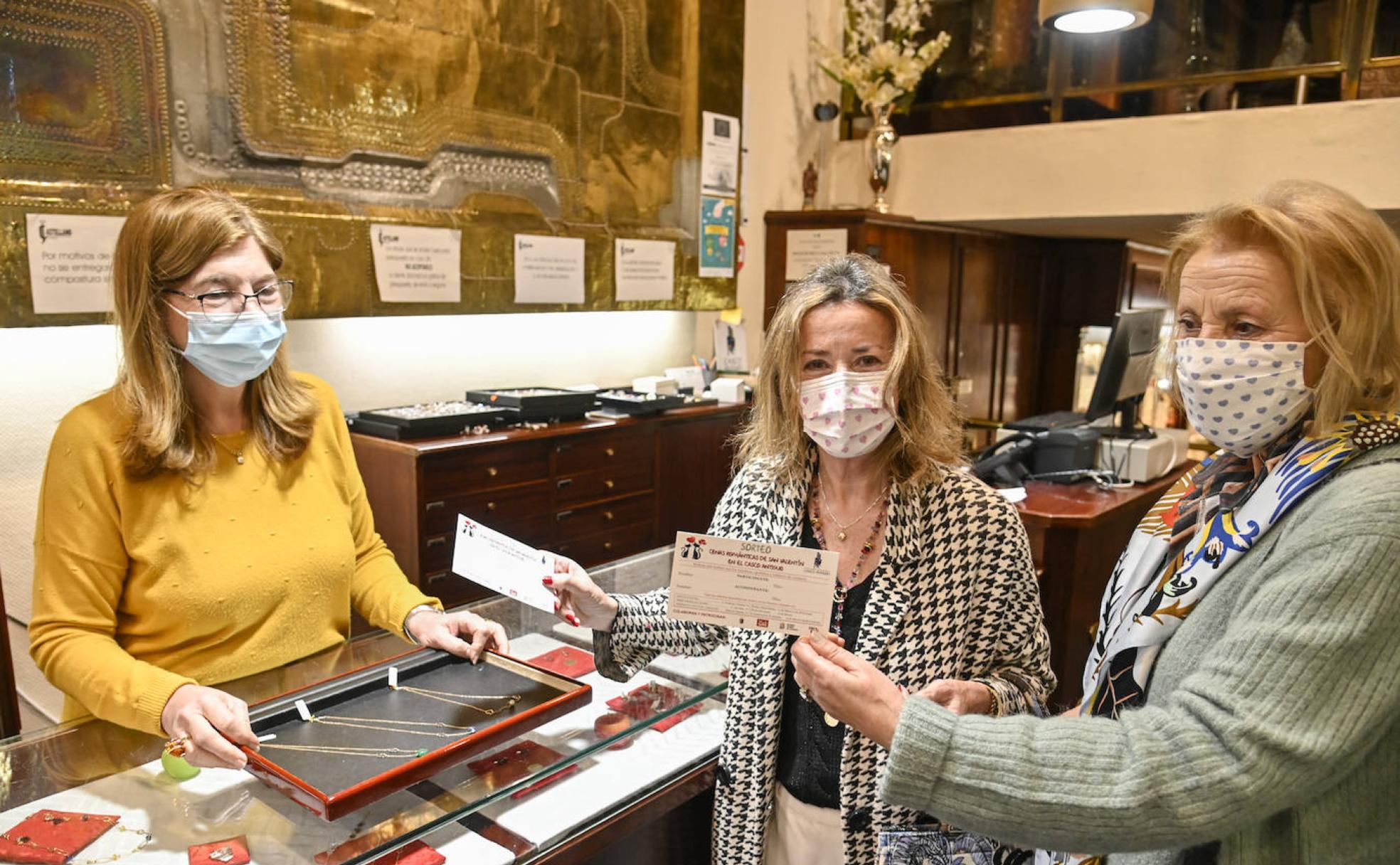 Dos clientas reciben sus participaciones en el sorteo de 