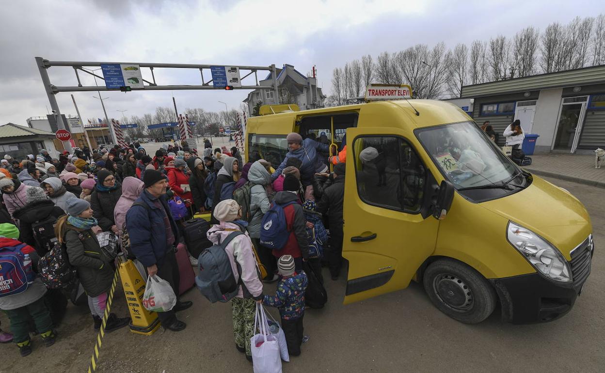 Los refugiados se agolpan para tomar un autobús en la frontera con Moldavia.