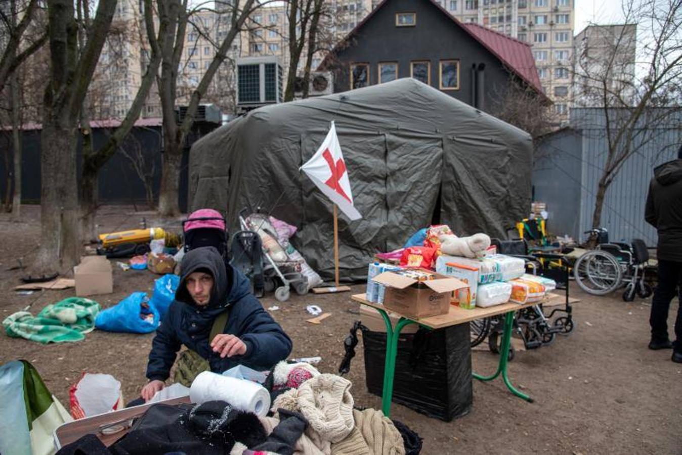 Un voluntario distribuye ropa a los ciudadanos que huyen en la entrada de Iripin.