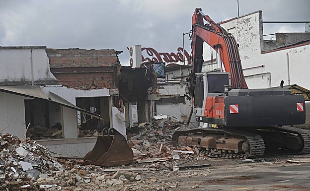 Imagen principal - Arriba, una máquina inició ayer el derribo de la estructura de la embotelladora de Coca-Cola en Badajoz. Abajo, a la izquierda, una excursión escolar; a la derecha, una página de HOY en 1967.