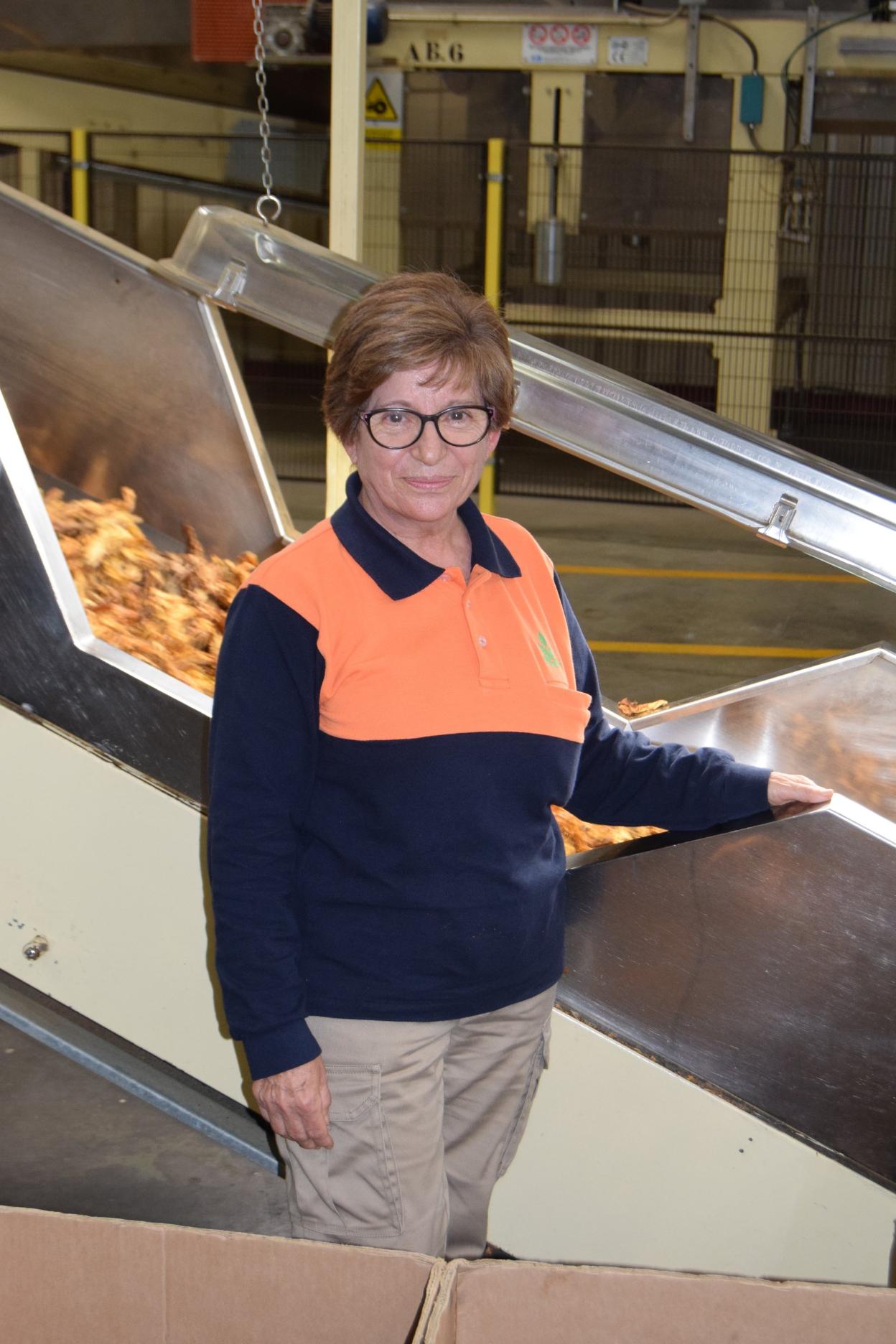 Rosa María posa junto a la máquina en la que selecciona tabaco. 