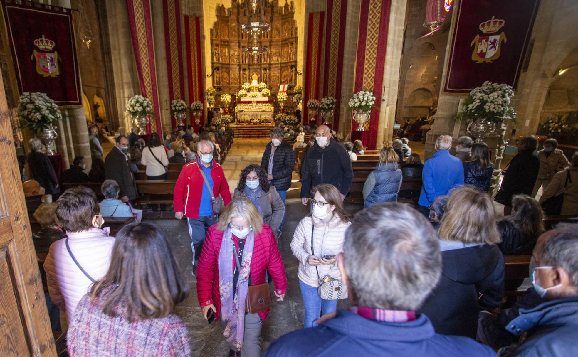Personas entrando y saliendo de la concatedral de Santa María, con la Virgen de la Montaña al fondo en el altar. 