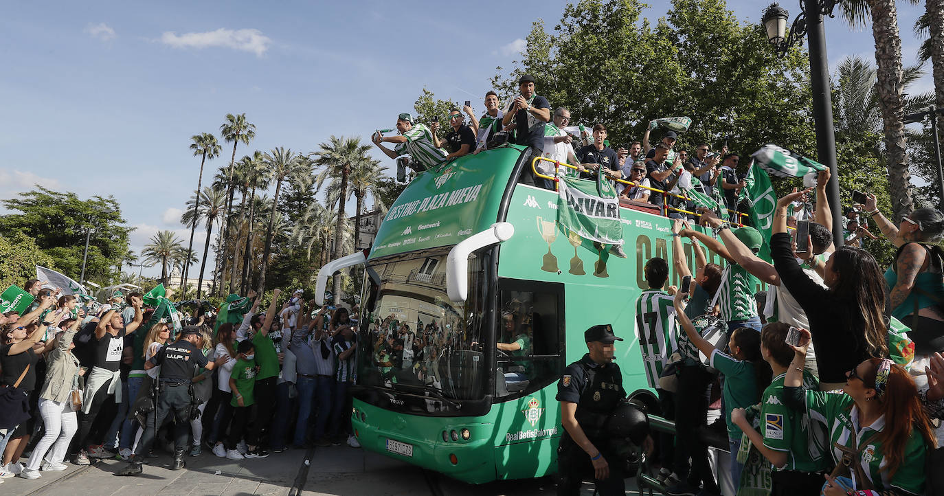 Jugadores del Betis saludan desde el autocar durante su recorrido con destino al ayuntamiento de Sevilla, para celebrar su título de Copa del Rey.