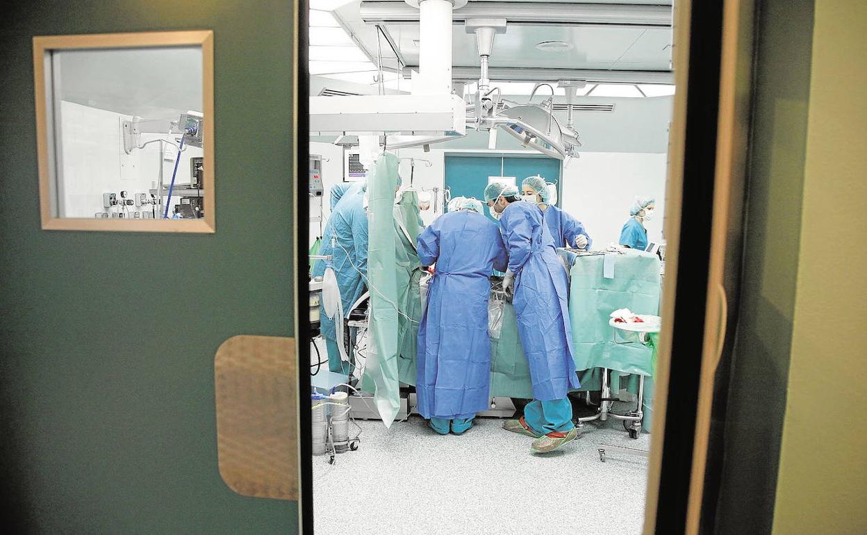 Un grupo de cirujanos realiza una operación en el quirófano de un hospital.