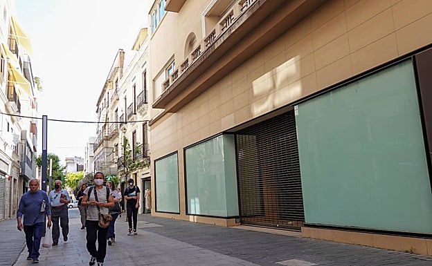 Viandantes caminan este miércoles por la puerta del local del antiguo Zara en la calle Menacho. 