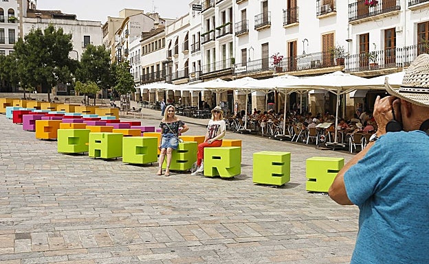 Dos turistas se hacen una foto en las letras que estos días decoran la Plaza Mayor. 