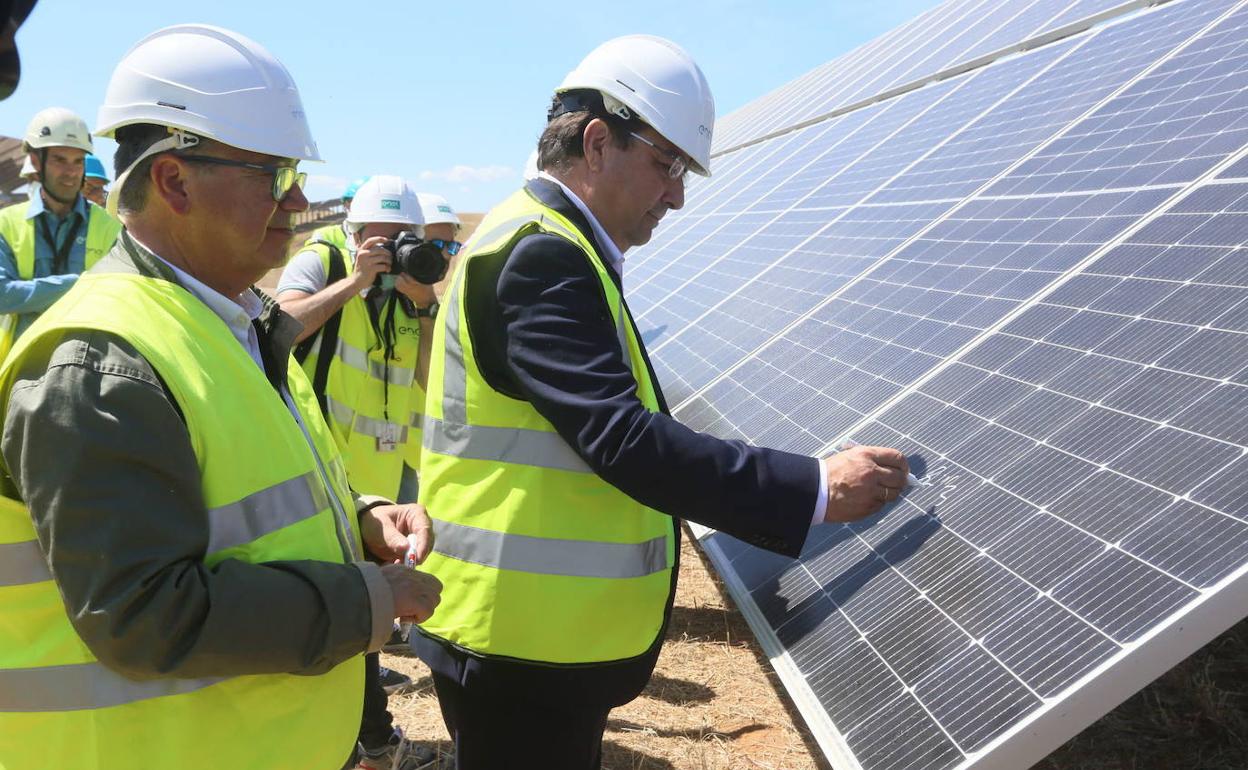 Guillermo Fernández Vara firma en mayo pasado en una placa solar de la fotovolaica El Doblón, entre Mérida y Almendralejo. Al lado, el alcalde almendralejense, Josée María Ramírez.