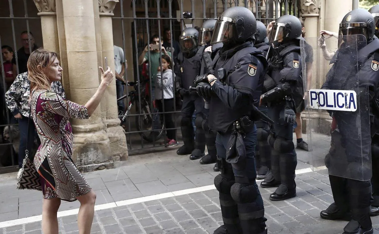Una mujer graba a un grupo de antidisturbios durante una protesta en Pamplona.