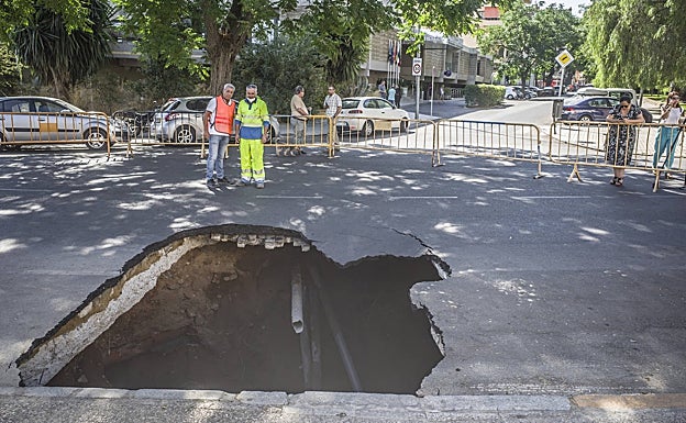 Socavón sobre el asfalto en el que ha caído el coche.