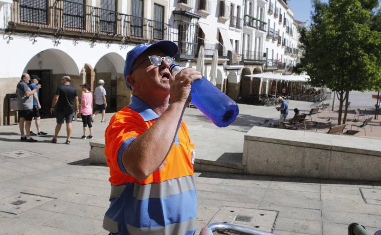 Un operario de Conyser se refresca durante un servicio de limpieza en la Plaza Mayor. 