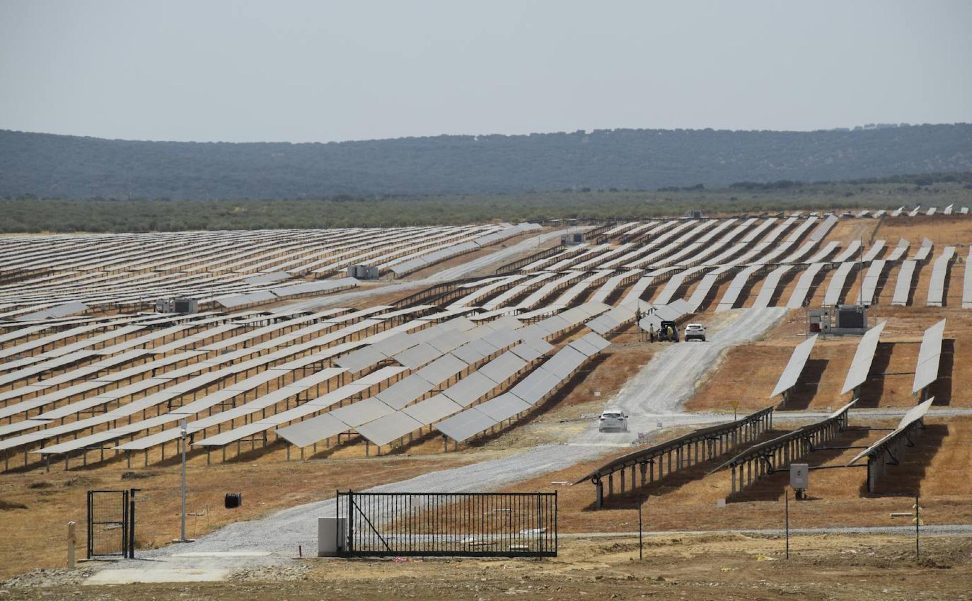 Dos vehículos circulan ayer entre los paneles solares de la fotovoltaica Francisco Pizarro, entre Aldeacentenera y Torrecillas de la Tiesa. 