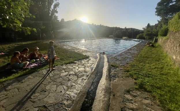 La piscina están en medio de un paisaje de cultivos y arboleda. 