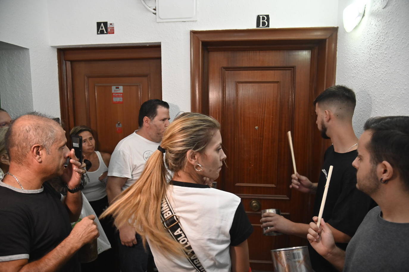 Vecinos protestando anoche en el rellano del piso okupado en Badajoz. 