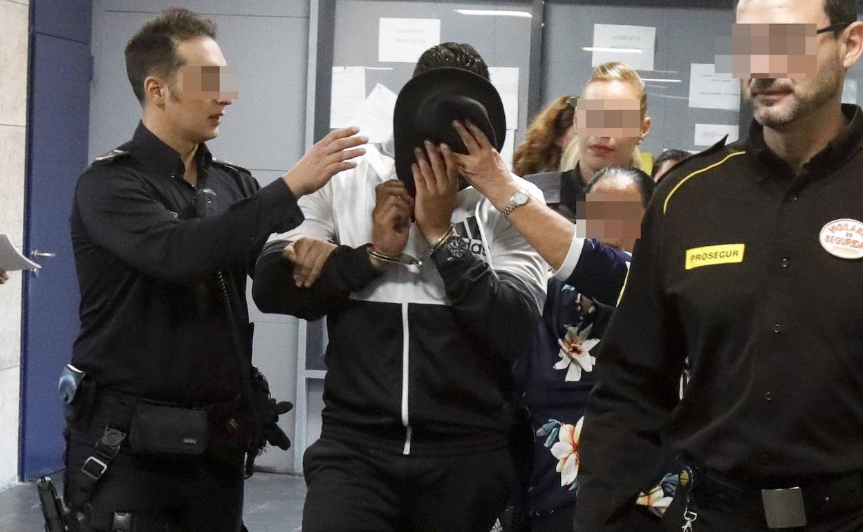 Agentes conduciendo a un violador para ser juzgado en la Audiencia Provincial de Cáceres. 