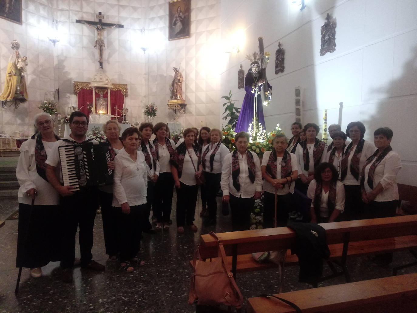 Imagen principal - Arriba, componentes del Coro de Nuestra Señora de los Santos de Táliga, que amenizaron con su misa extremeña la liturgia del 14 de septiembre. Abajo, a la izqiuerda, el escritor Fermín Mayorga junto a hermanas de la Cofradía de la Santa Cruz. A la derecha, el Nazareno, imagen titular de la Hermandad. 