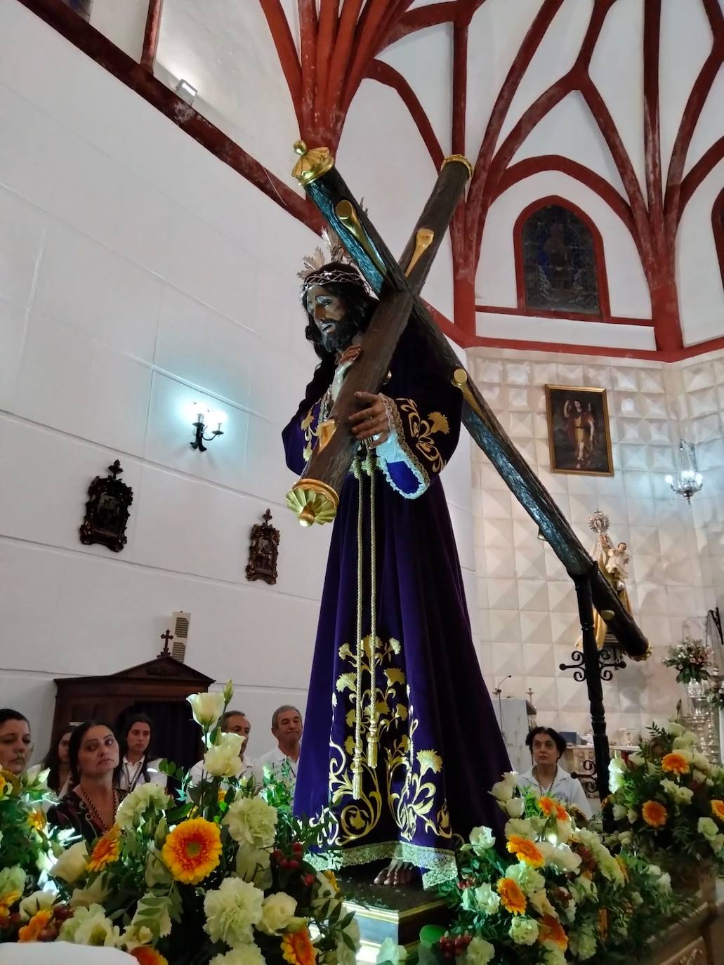 Imagen secundaria 2 - Arriba, componentes del Coro de Nuestra Señora de los Santos de Táliga, que amenizaron con su misa extremeña la liturgia del 14 de septiembre. Abajo, a la izqiuerda, el escritor Fermín Mayorga junto a hermanas de la Cofradía de la Santa Cruz. A la derecha, el Nazareno, imagen titular de la Hermandad. 