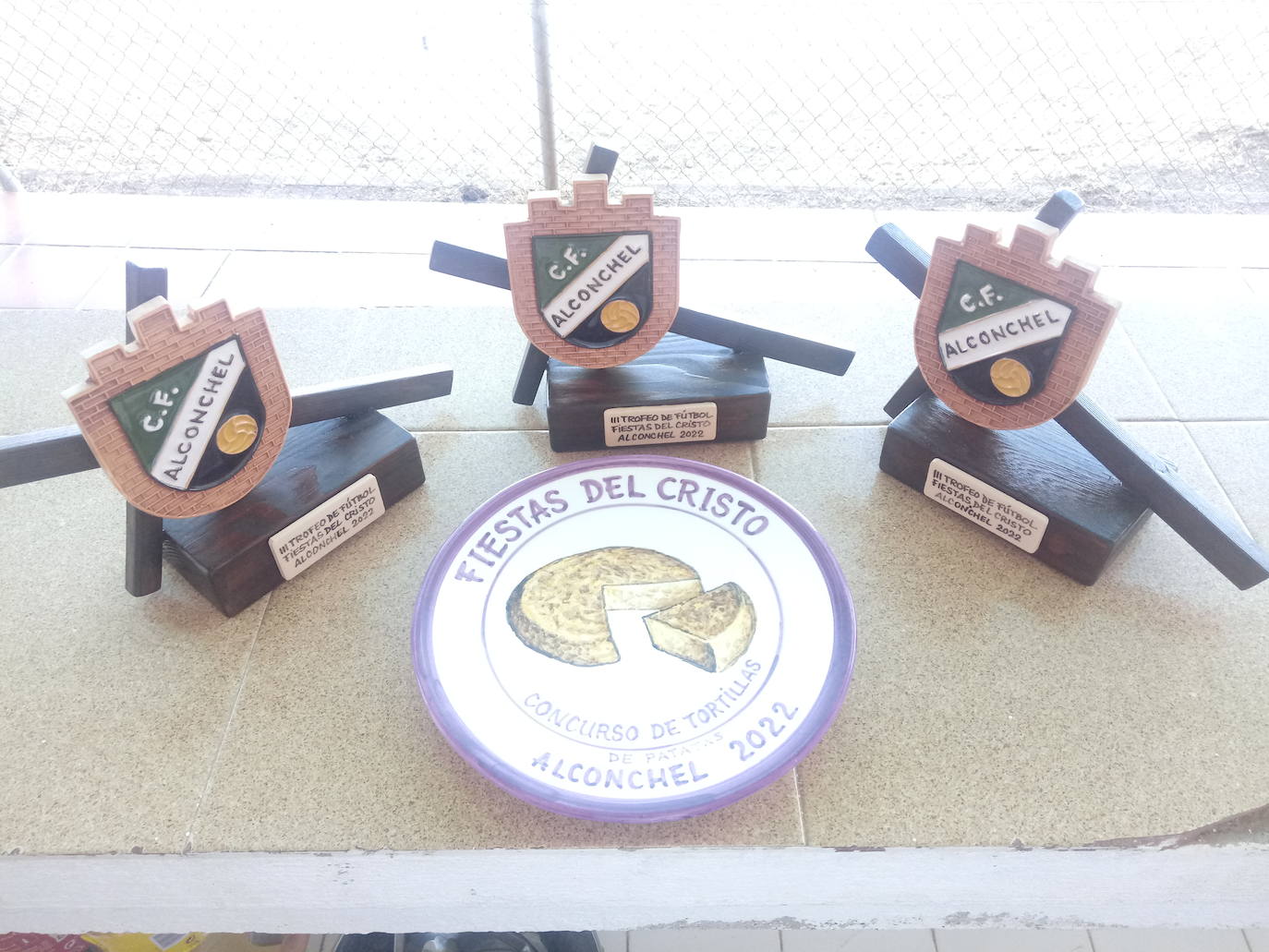 Imagen secundaria 2 - Arriba, participantes en el Torneo de Fútbol organizado por el Club de Fútbol Alconchel. Abajo, a la izquierda, componentes de la Banda de Cornetas y Tambores 'Villa de Alconchel'. A la derecha, trofeos elaborados por Cerámica Artística Villanovense para las fiestas de este año. 