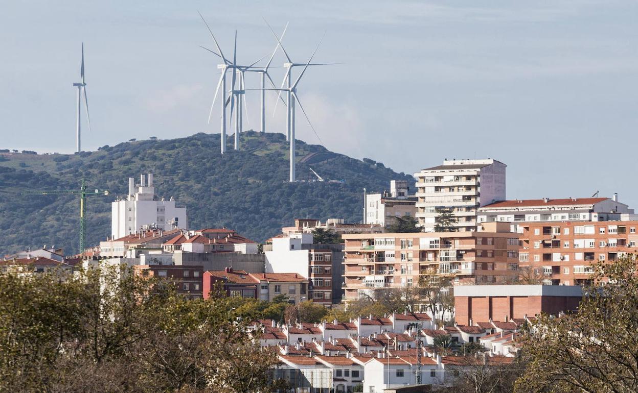 Plasencia, y al fondo, los aerogeneradores del parque eólico 'El Merengue 1'.