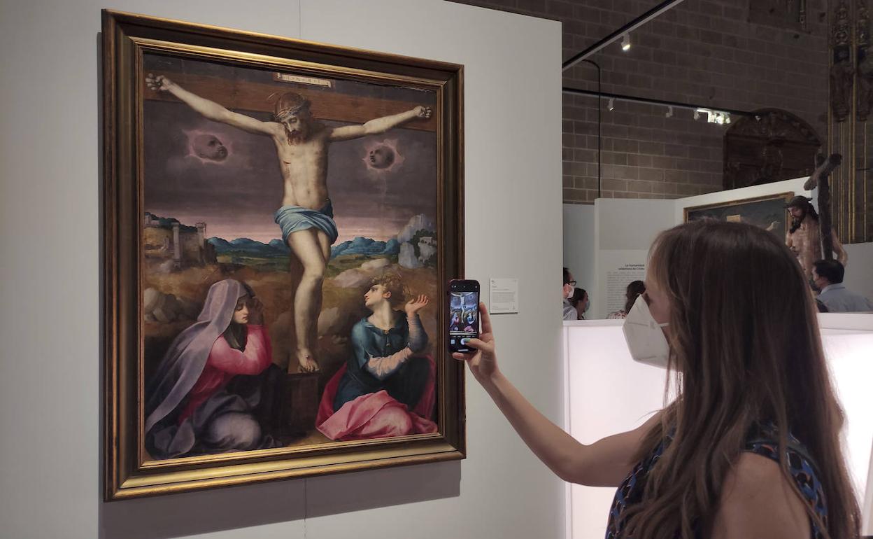 Una visitante contempla una de las 180 obras de arte sacro extremeño de la muestra.