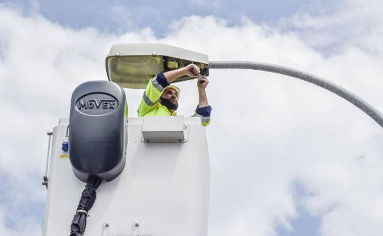 Un operario sustituye una farola tradicional en 2018 por un equipo led, que consumen menos. 