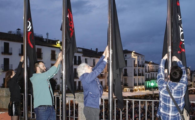 Izado de banderas del encuentro en la fachada del Ayuntamiento. 