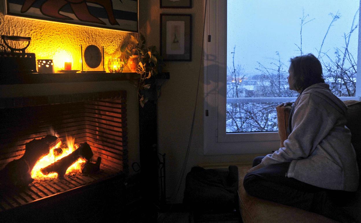 Mujer frente a chimenea.