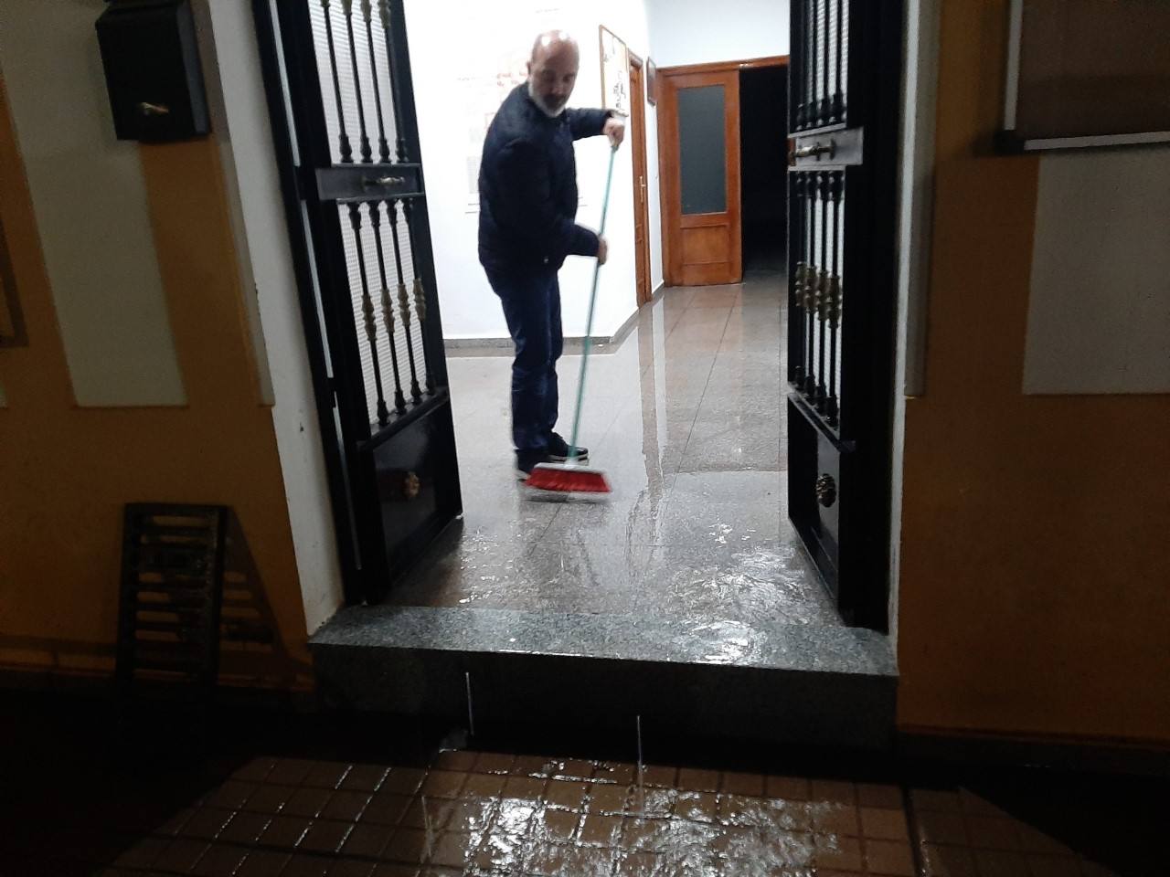 Juan Barrientos achicando agua en la Casa del Pueblo 