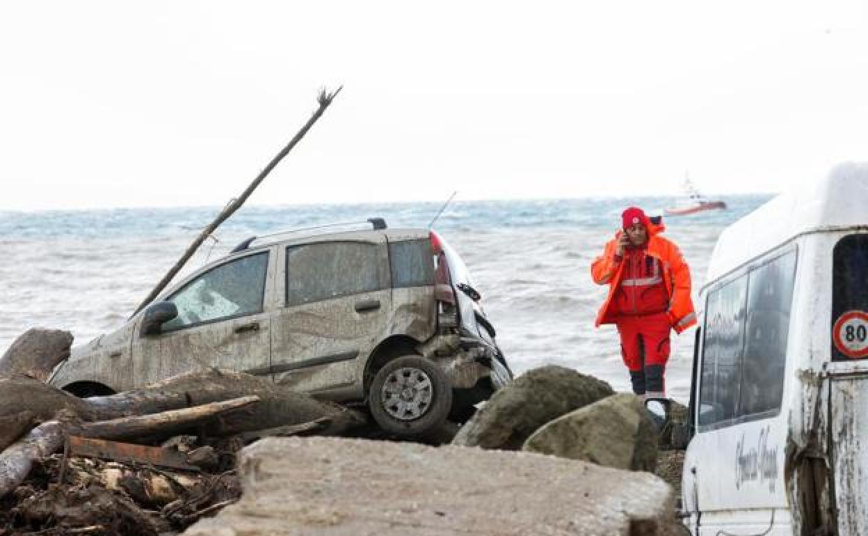 Un rescatista habla por teléfono cerca de autos dañados junto al mar, luego de un deslizamiento de tierra en la isla vacacional italiana de Ischia, Italia, 26 de noviembre de 2022.