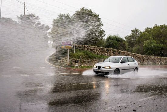 Foto de archivo de un coche circulando con fuertes lluvias 