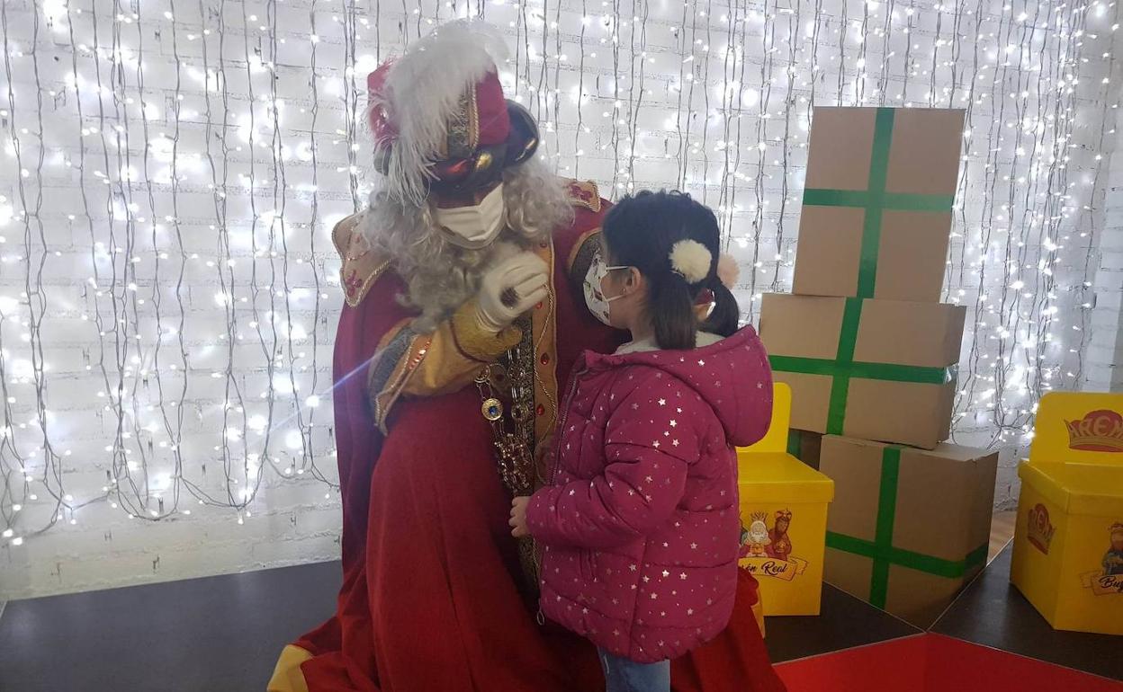 Imagen de archivo. Una niña hablando con uno de los Reyes Magos. 