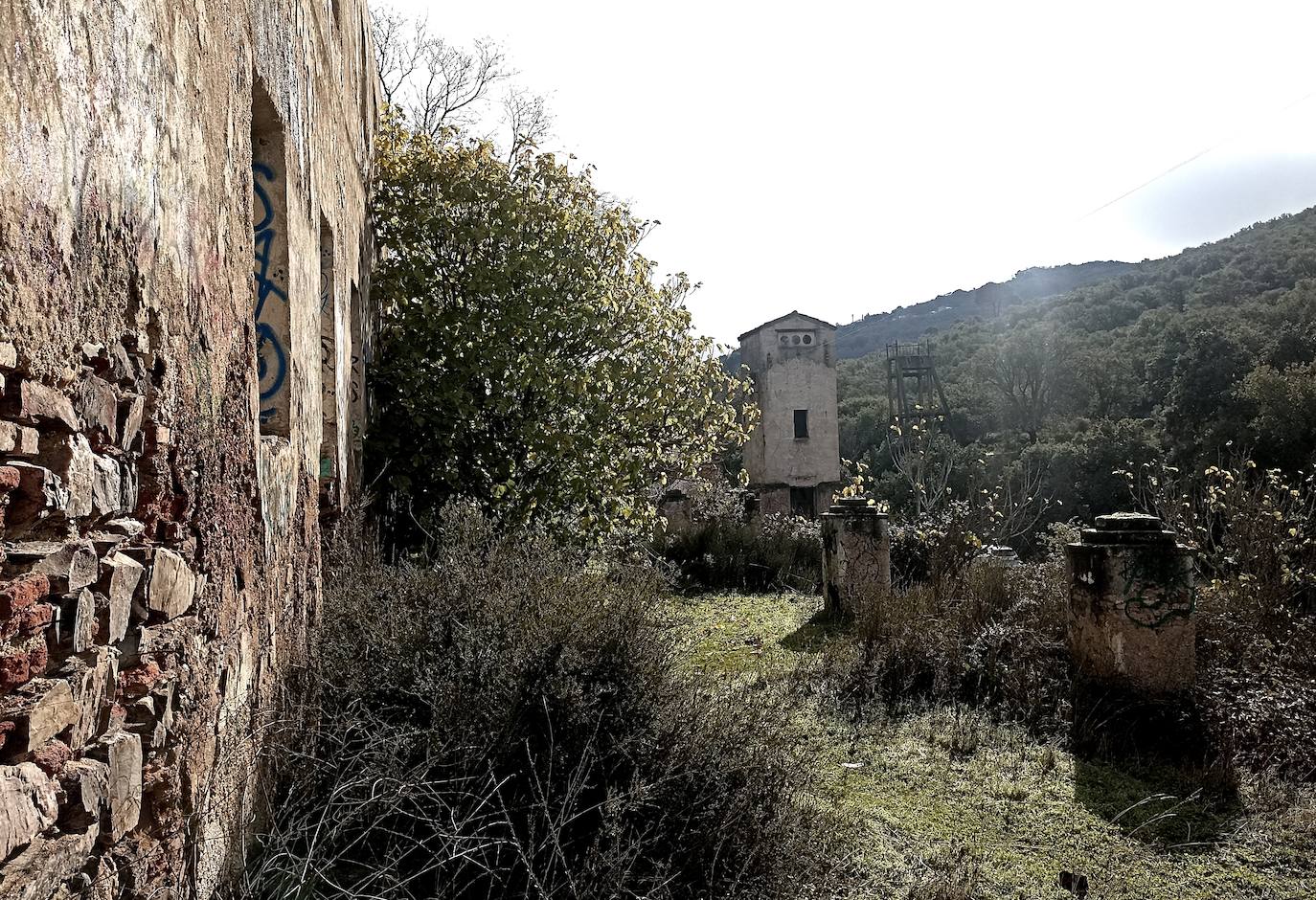 Torreta y elevador de las minas junto al edificio grande en ruinas.