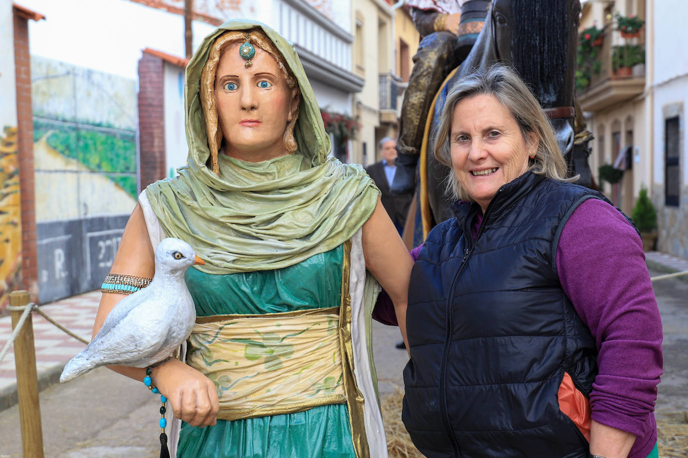 Una vecina de Villar de Rena posa junto a su doble, plasmada en una figura. 