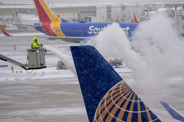 Un operario retira el hielo de un avión de United Airlines tras el paso de un frente frío por el aeropuerto internacional General Mitchell de Milwaukee, Wisconsin.